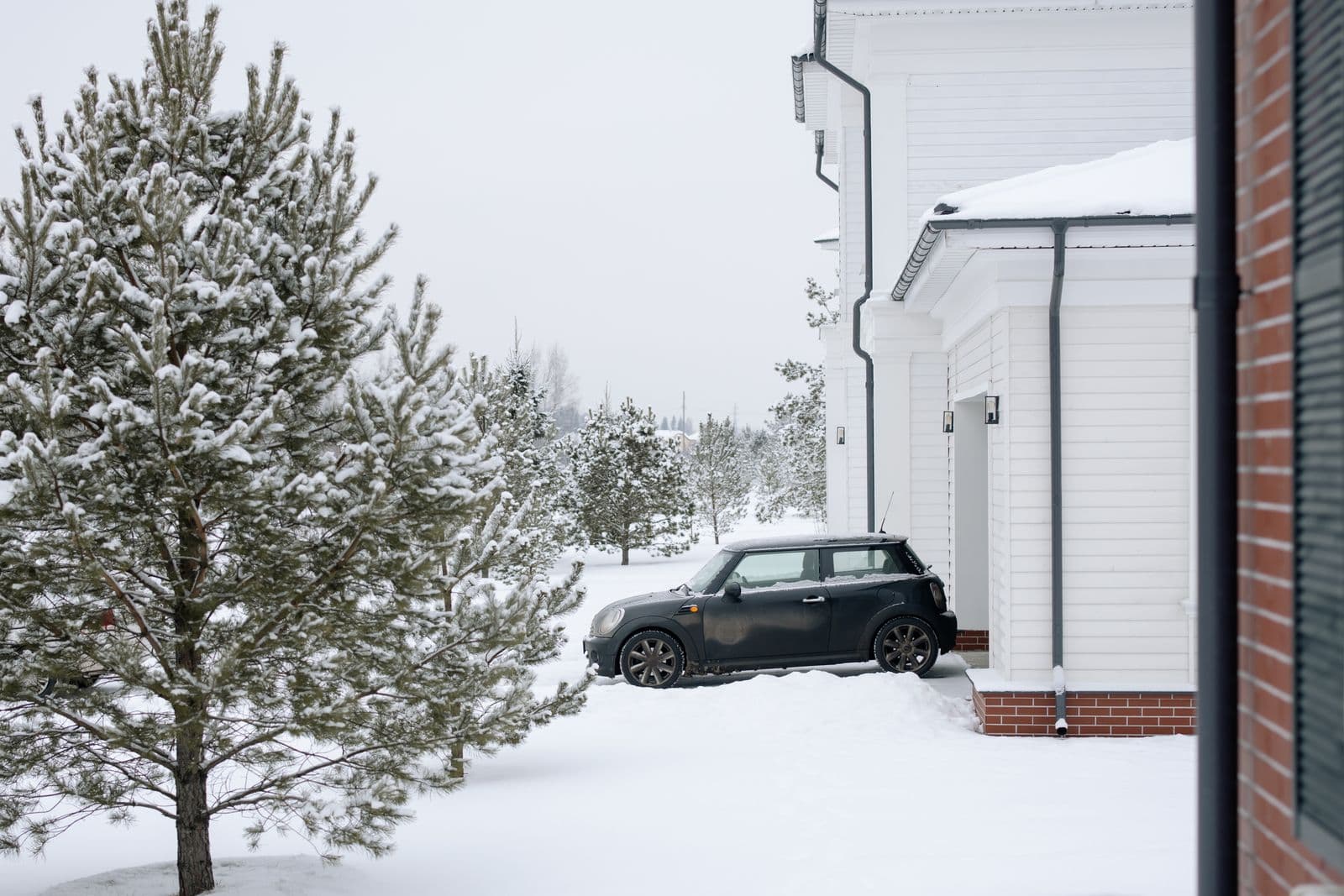 Auto geparkeerd in de sneeuw bij een woonhuis