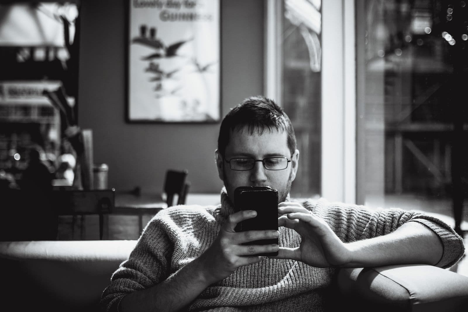 Koper leest recensies op een telefoon voordat hij een showroom bezoekt